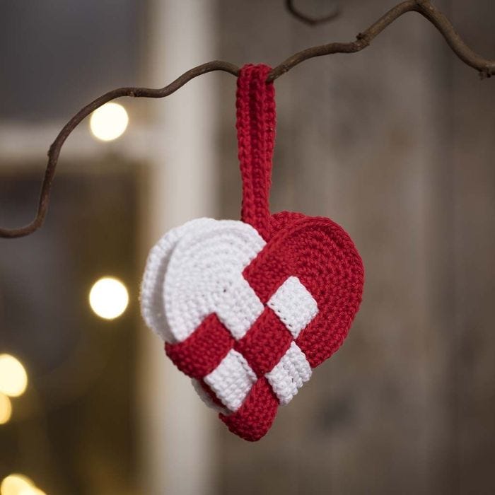 A crocheted woven Christmas heart basket from red and white cotton yarn