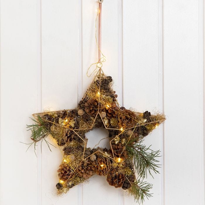 A Metal Star for a Door Decoration decorated with Cones, Lametta etc.