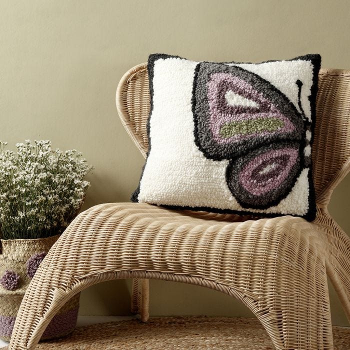 A cushion with a butterfly design made with a punch needle