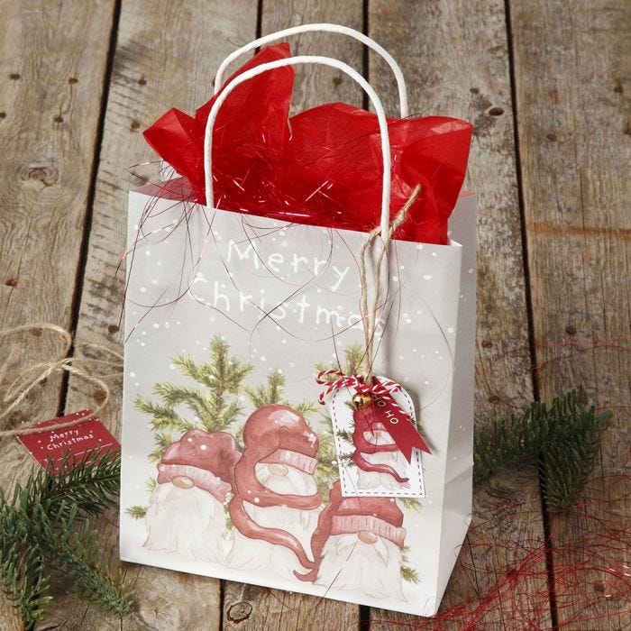 Christmas gift wrapping with a  gift bag and gift tag with a bell