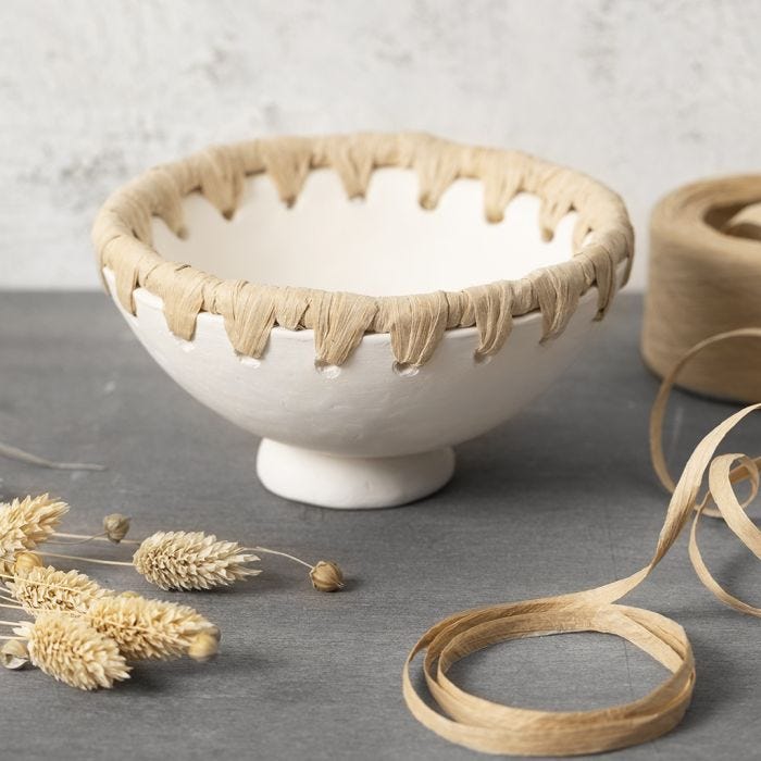 A bowl from self-hardening clay with a paper raffia rim