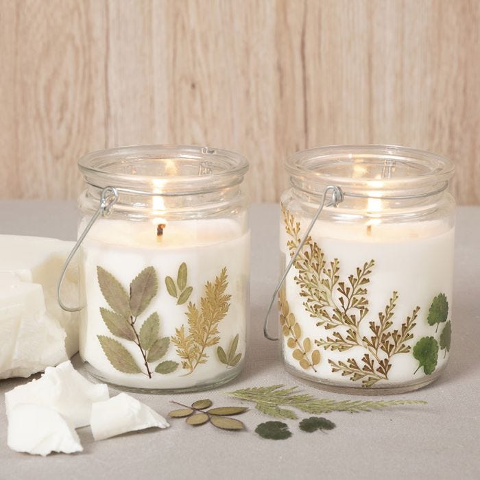 Rapeseed wax candles in a glass lantern decorated with dried flowers