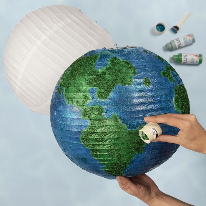 A globe from a rice paper lamp decorated with craft paint and bio glitter