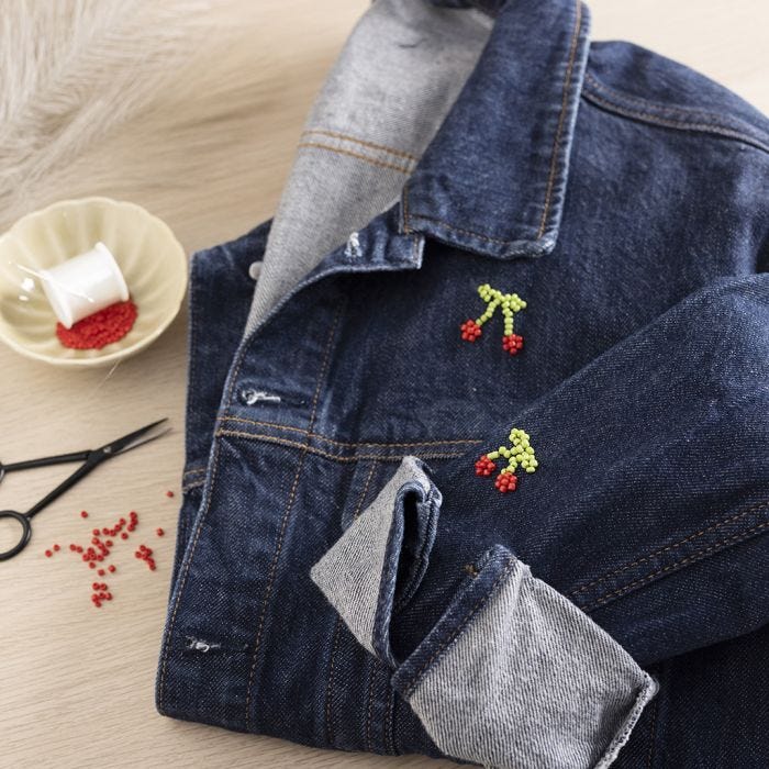 Bead-embroidered cherries on a denim jacket