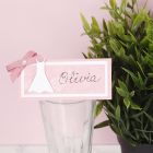 A place card for a confirmation party decorated with a dress and a bow