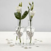 A Glass Vase with a wooden Heart secured by a white Satin Ribbon Waistband