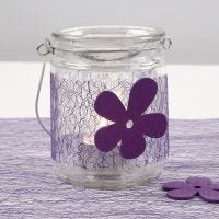 A Candle Holder with a purple Net Waist Band and a wooden Flower