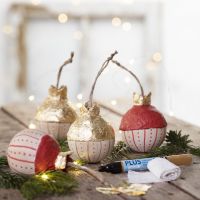 A wooden Christmas bauble with gold imitation metal leaf