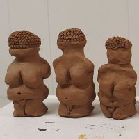Female sculptures from red earth clay